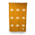 Handwoven blanket with peace symbols, part of Trek Light's eco-friendly bundle with leather carrier. Perfect for conscious living.