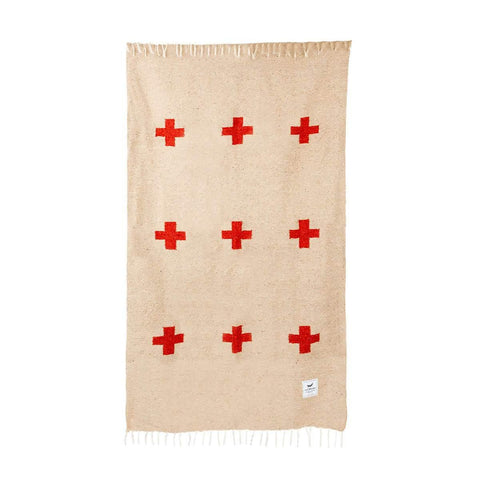 Positive Vibrations Blanket by Trek Light, handwoven with recycled materials, featuring unique red cross design and fringed edges.