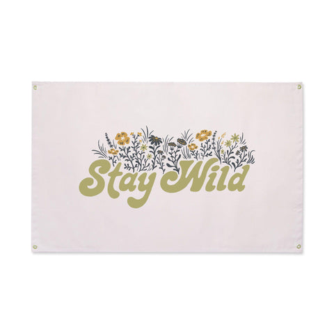 Trek Light Canvas Flag Wall Art with 'Stay Wild' print, featuring natural canvas, floral design, brass grommets, 31" x 48" size.