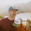 Happy couple wearing Trek Light Stay Wild hats enjoying a sunny outdoor adventure.