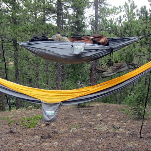 Trek Light VersaTrek mini hammock in the woods, doubled as a gear loft and swing, showcasing its versatility and strength outdoors.