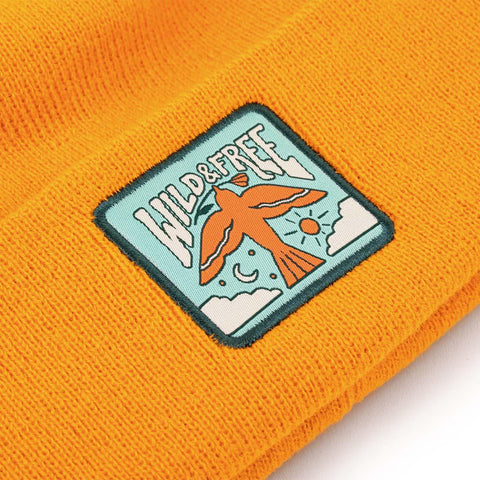 Wild & Free Kids Beanie in bright orange with Trek Light emblem featuring a bird and nature design.